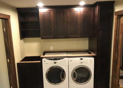 laundry room with dark wood cabinets